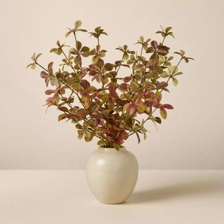 A faux branch in a simple white vase