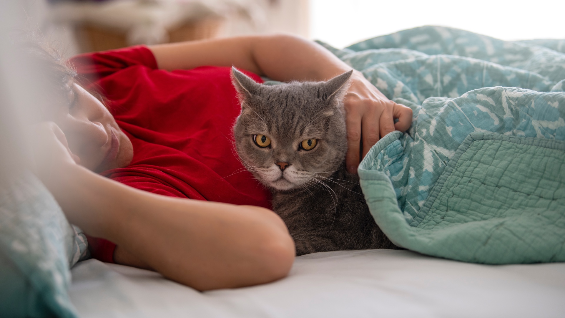 Woman and cat sleeping together