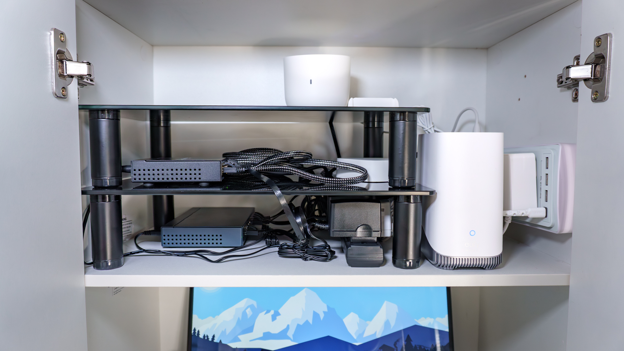 Various networking gear inside the top compartment of a kitchen pantry cabinet