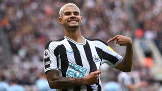 Newcastle player Bruno Guimaraes celebrates his second goal by pointing to the club badge during the Premier League match between Newcastle United and Brentford FC