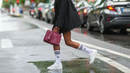 woman wearing trendy new sneakers with a blazer and hermes birkin bag