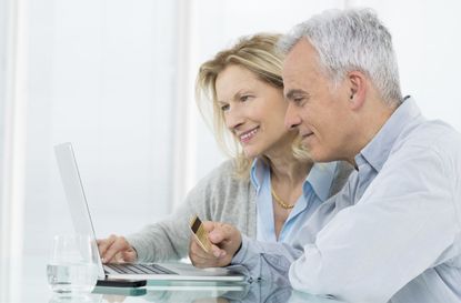 Portrait Of Senior Couple Shopping Online With Credit Card