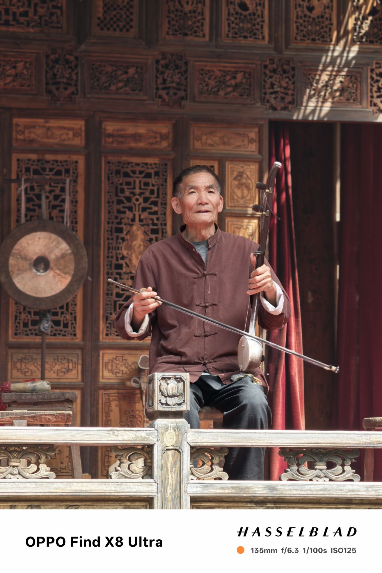 A person in traditional Chinese dress playing an instrument