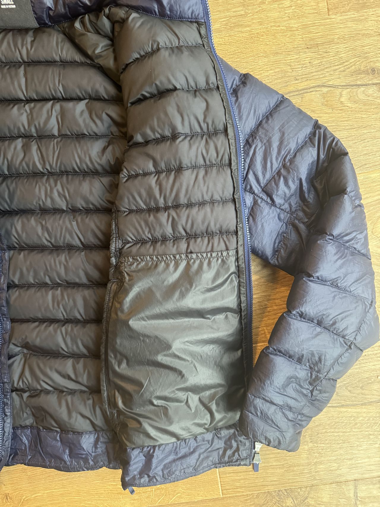 Flat lay jacket showing the size of the pockets. Inside quilted material is black.