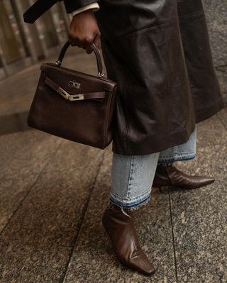 Coco matches leather brown ankle boots to a Hermes Kelly bag