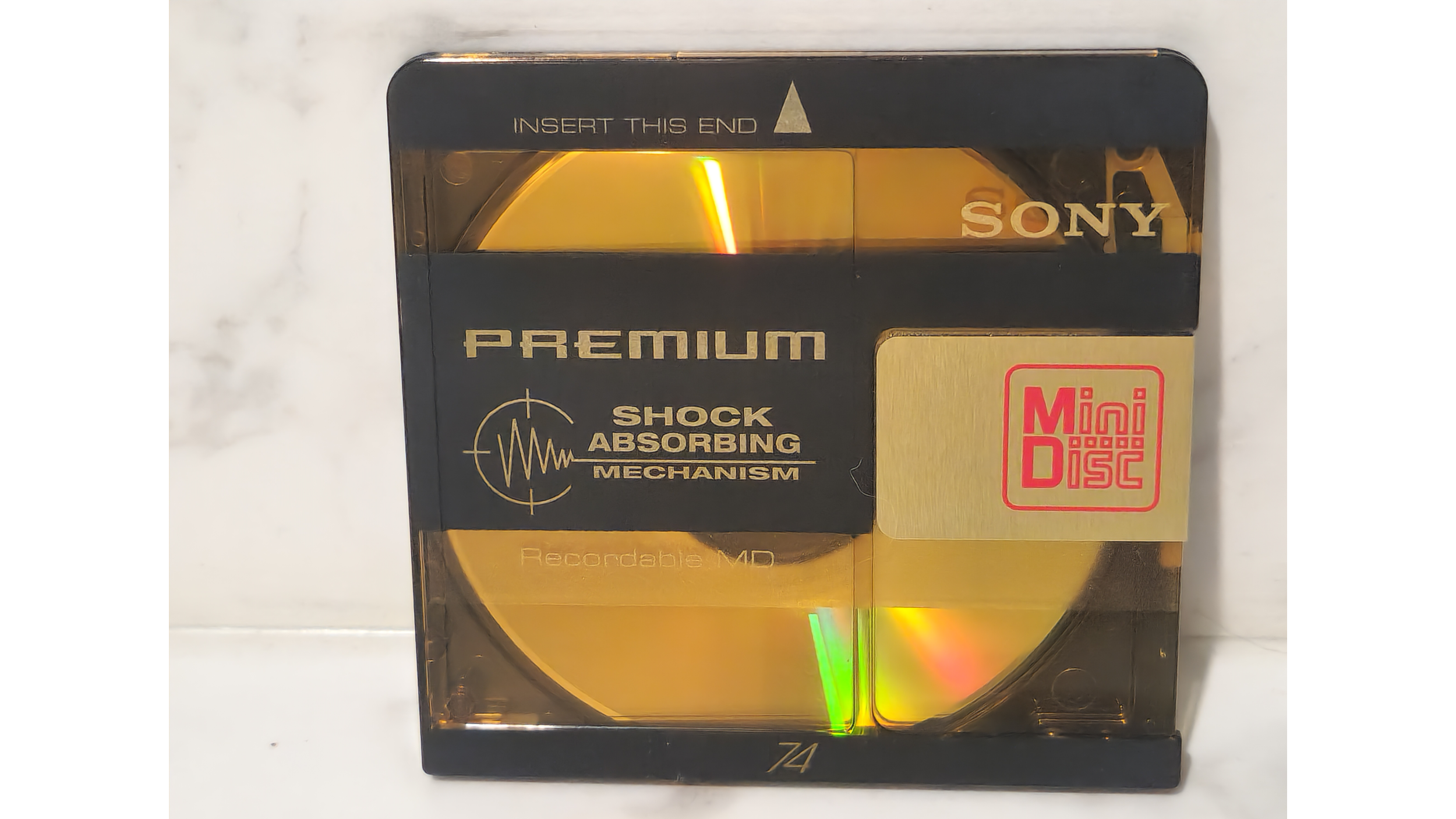 MiniDisc and case on white marble surface