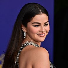 Selena Gomez looks over her shoulder wearing diamond earrings