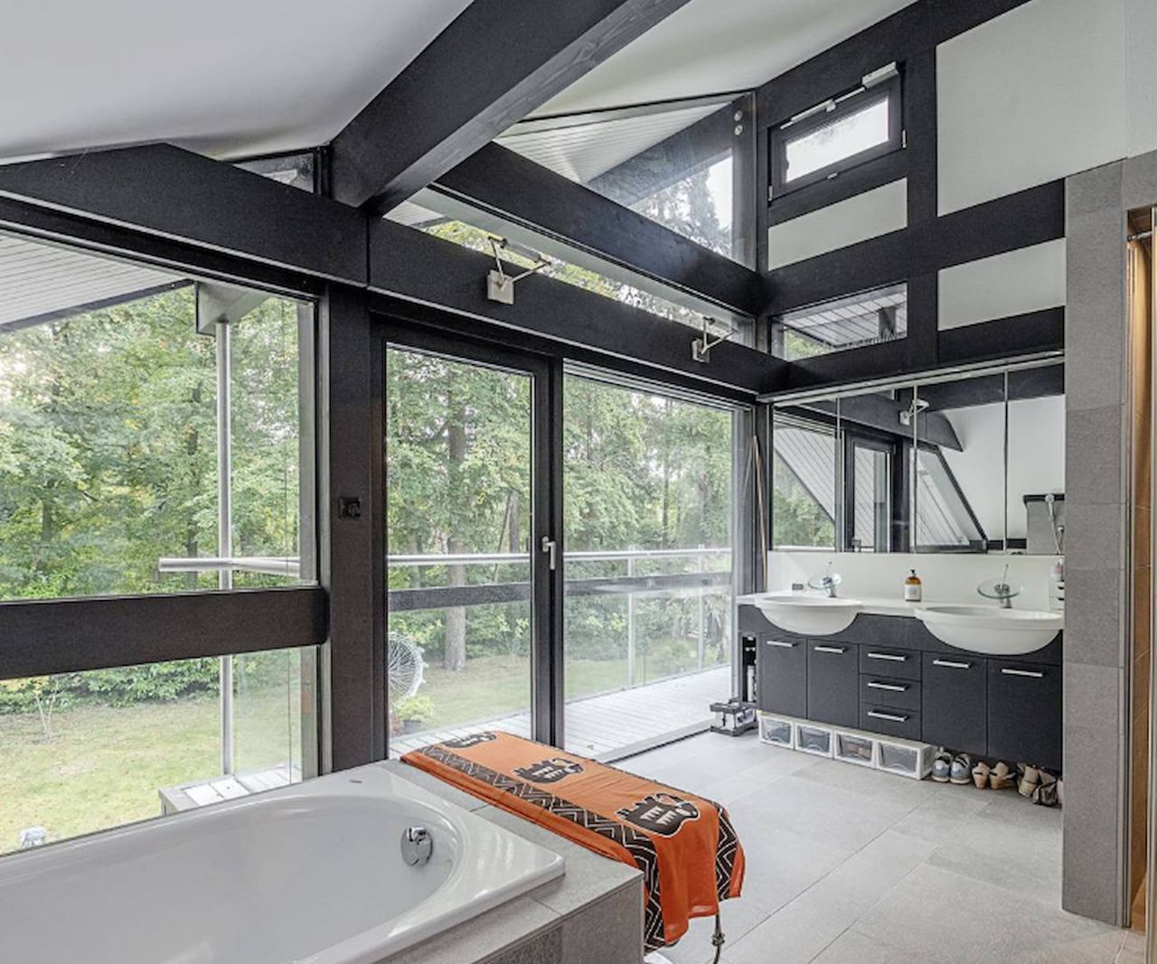 A bathroom with two sinks and grey ceramic surrounded porcelain bath