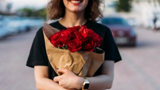Alla hjärtans dag: En kvinna som håller en bukett rosor.