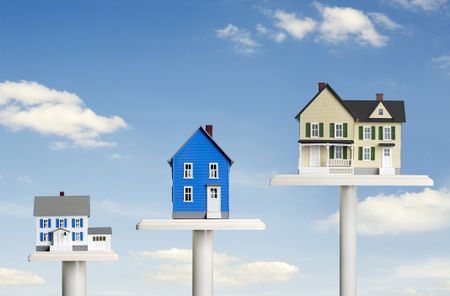 three houses on ascending pedestals against a blue sky background