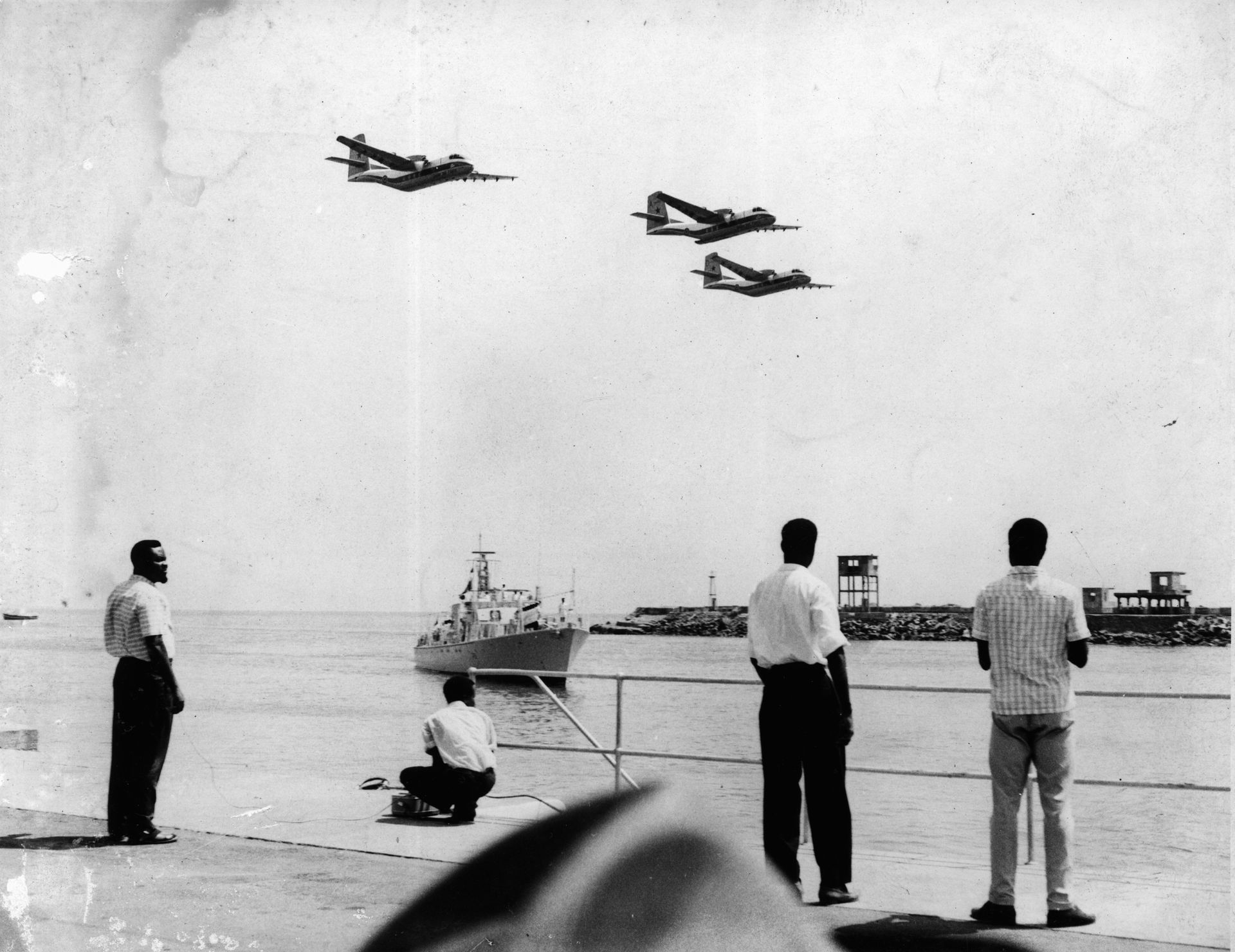 People harbourside watching planes. Image from JK Bruce-Vanderpuije exhibition at Efie Gallery Dubai
