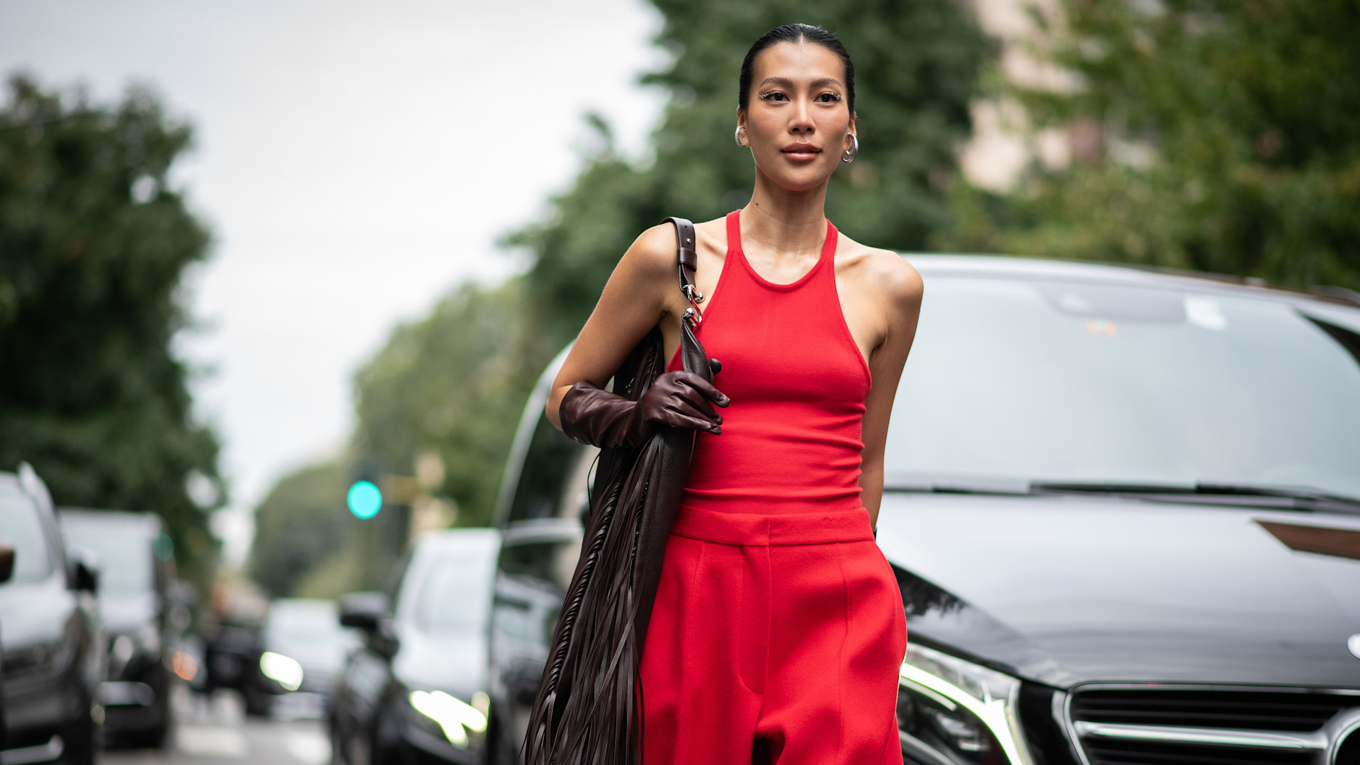 fashion week attendee wearing red tank top, red pants, brown glove