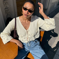 Lena wearing a crochet blouse and blue jeans