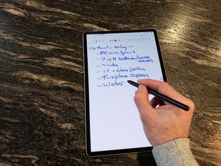 Samsung Galaxy Tab S8 Plus on desk showing someone writing on it