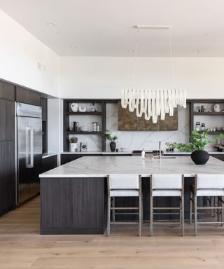 white kitchen with marble countertops, blond wood flooring, grey:brown cabinets, open shelving