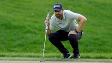 Patrick Rodgers crouches down behind a putt during the Memorial Tournament in 2026