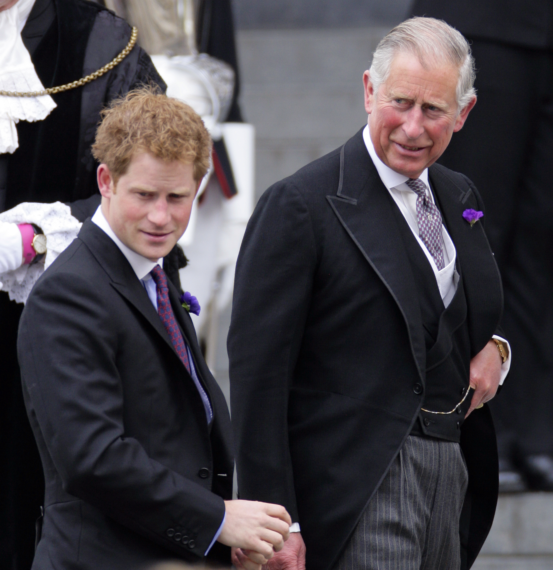 King Charles and Prince Harry standing next to each other in suits
