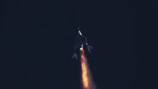 A space plane fires its rocket engine against a dark sky.