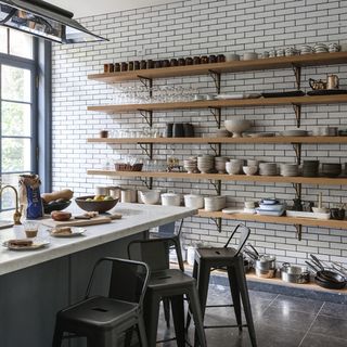 kitchen with white brick wall wooden shelves and marble countertop
