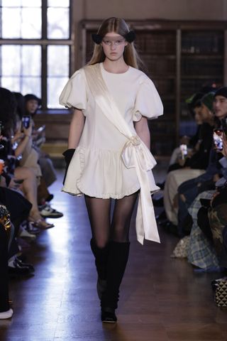Model on runway in Sandy Liang white dress