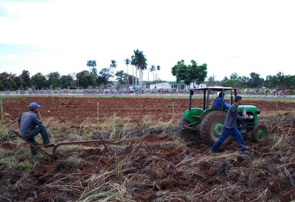 Farmers take a break as the Vuelta a Cuba peloton races past