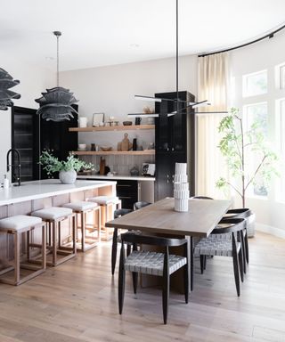 sticking to budget, open plan kitchen with dining area, white countertops, statement pendant lights, open shelving, black cabinetry