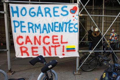 Protest sign in front of migrants camping out in front of the Watson Hotel in NYC