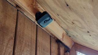 A Blink Outdoor Camera mounted on the underside of a chicken run roof