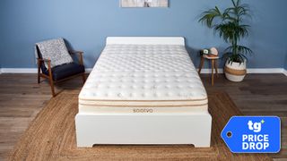 The Saatva Classic mattress on a bed frame in our Tom's Guide Sleep Studio. In the bottom right corner, a Tom's Guide price drop deals badge
