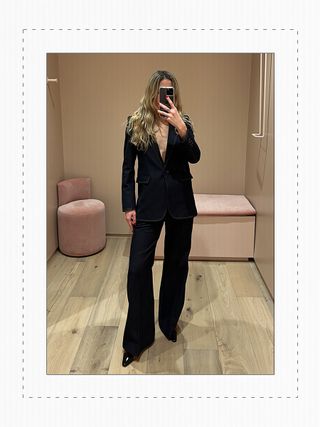 Eliza Huber in the dressing room at Me+Em's new NYC store wearing a denim suit.