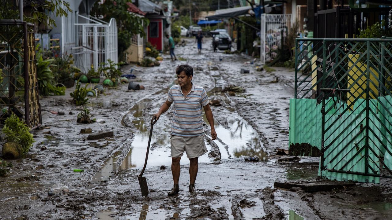 A man shovels mud out of his house after Typhoon Goni hit the Philippines