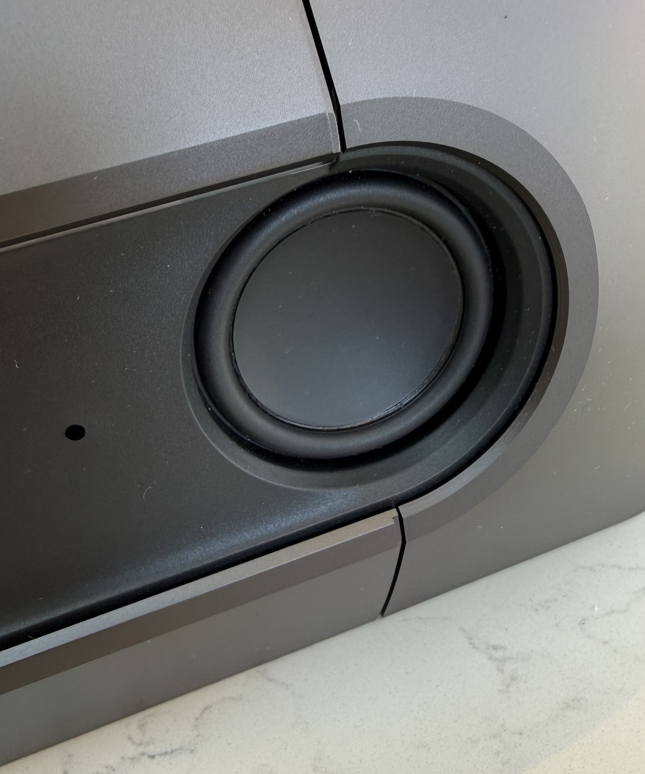 Detailed close-up of a circular speaker embedded within the soundbar casing