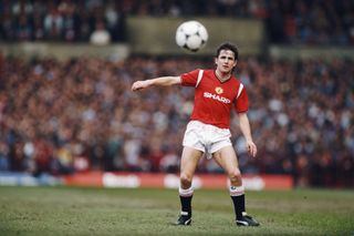 Manchester United defender Arthur Albiston passes an adidas tango football during a League Division One match against Manchester City at Old Trafford in March 1986 in Manchester, England.