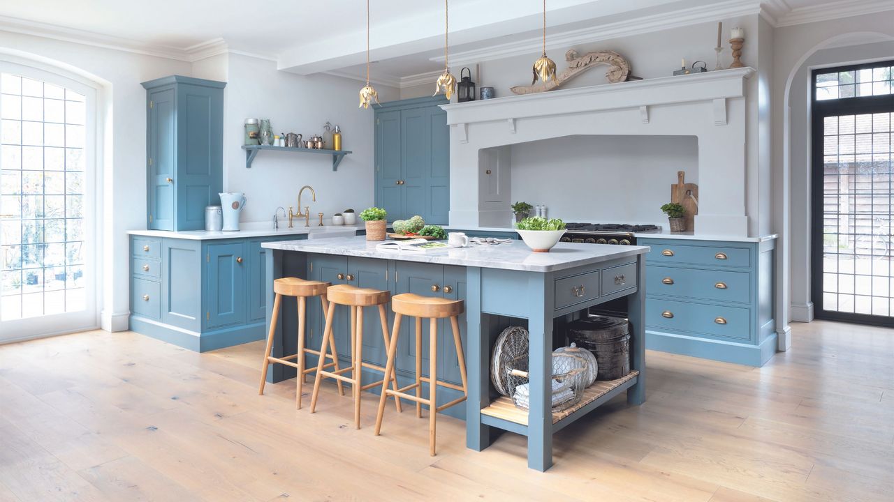 blue shaker-style kitchen with blonde wooden floor