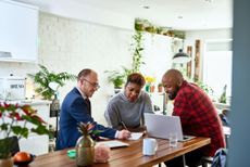 a couple sitting at a desk going through financial plans with an advisor 