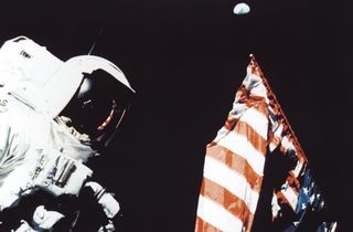 Astronaut Harrison Schmitt with the American flag and the Earth in the background, during a trek on the lunar surface as part of the Apollo 17 mission.