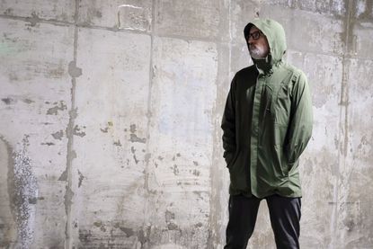 A man with a beard wearing an Altura Grid Parka in a garage