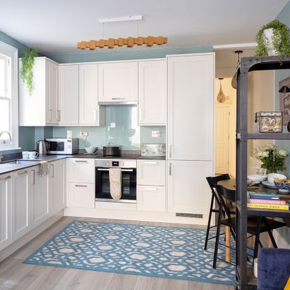 modern white kitchen with blue walls and blue rug