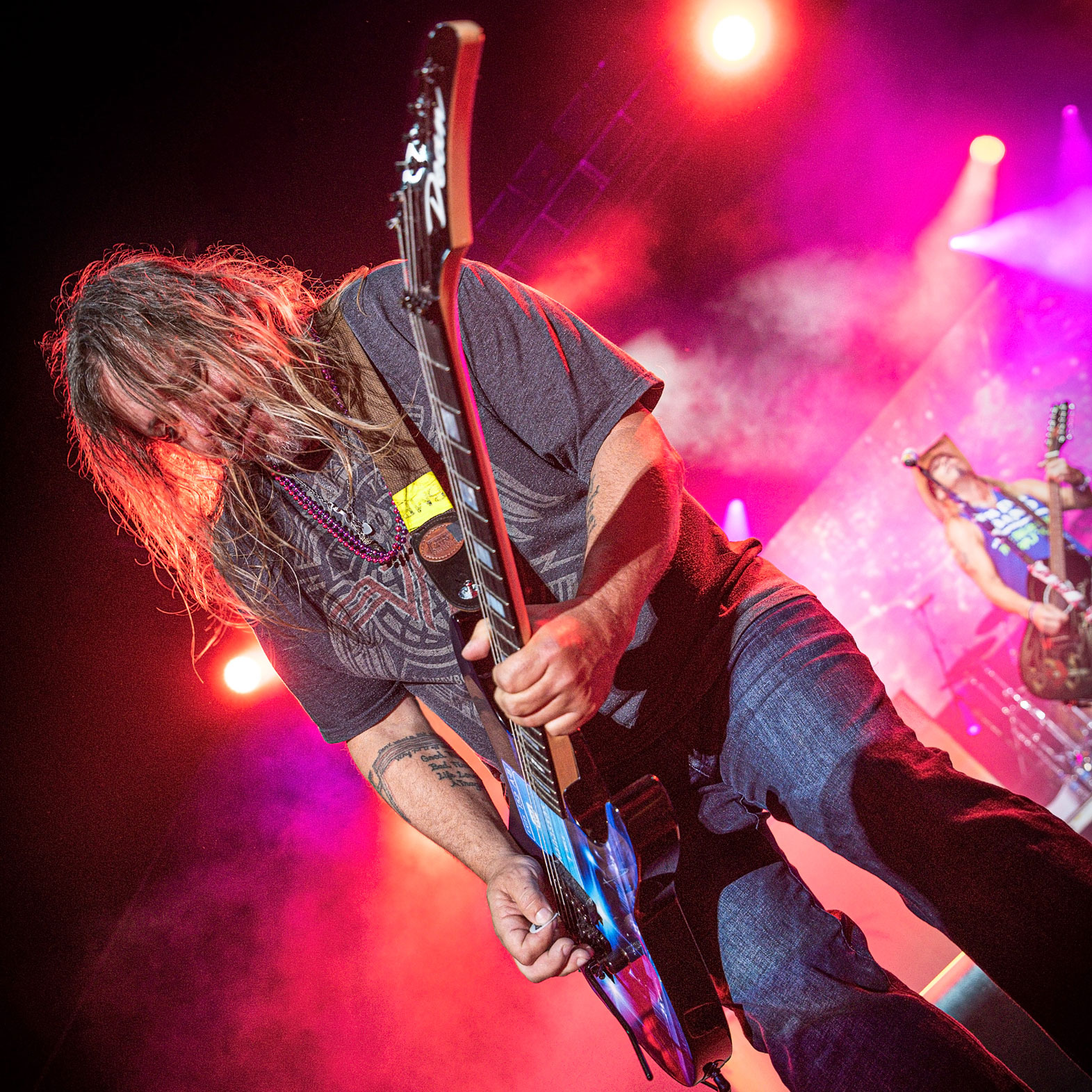 An angled image of Pete Evick playing guitar onstage