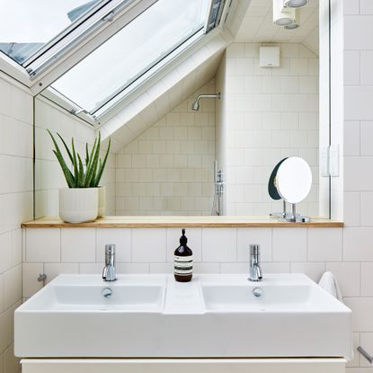 Double bathroom sinks with large mirror under eaves