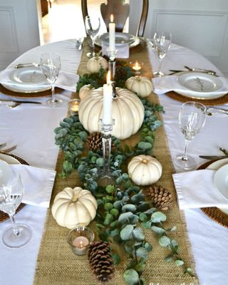 White dining table cloth with burlap runner and white pumpkins