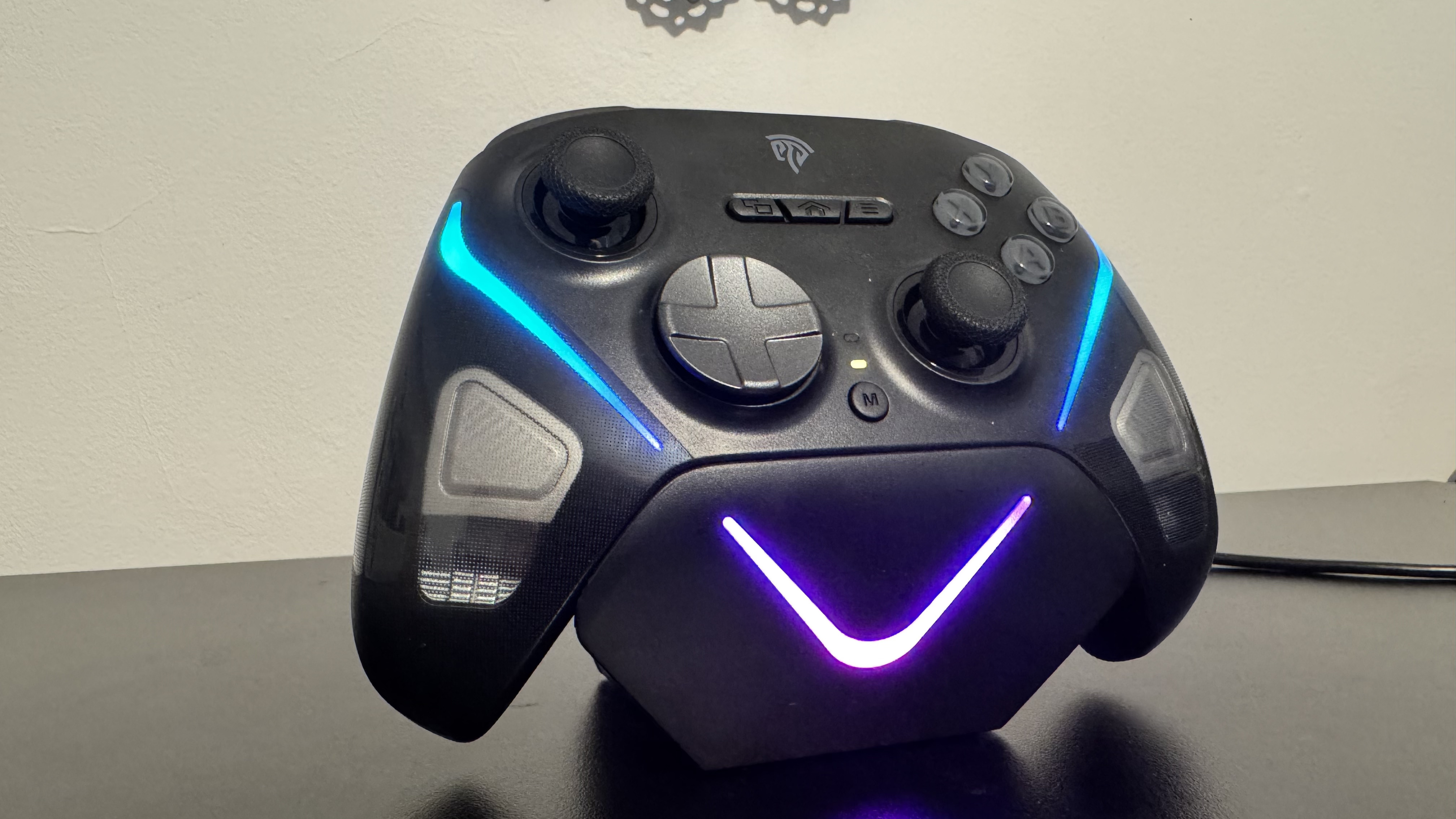 EasySMX D10 on a turned on charging stand, on a black desk