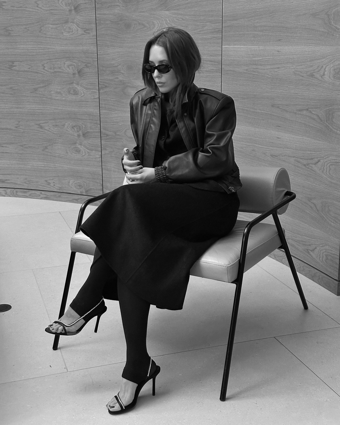 Debora Rosa wearing a leather jacket and footie leggings with heeled sandals.