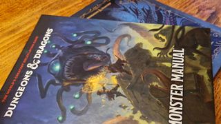 Both versions of the Monster Manual laid out on a wooden surface