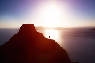 A man climbs a coastal mountain