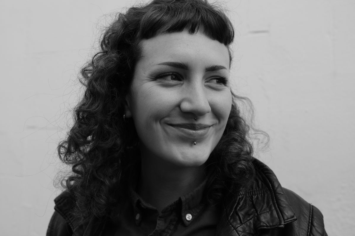 A black and white portrait of a woman with curly hair, taken on a Fujifilm X-T50