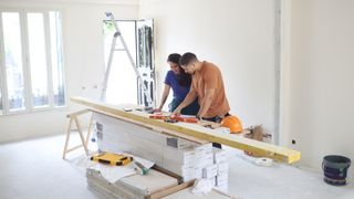couple in main reception room of home mid renovation