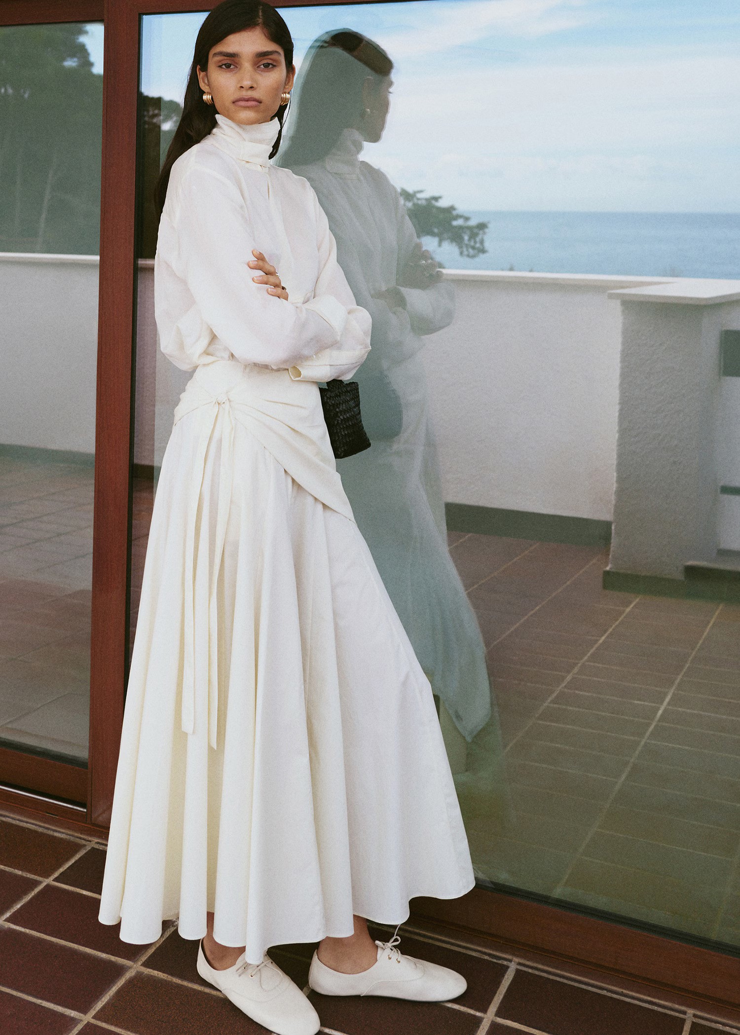 Woman wears white top, white skirt