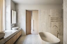 A bathroom in muted tones, finished with earthy materials