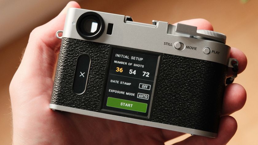 Fujifilm X Half camera held in a hand showing the film camera mode
